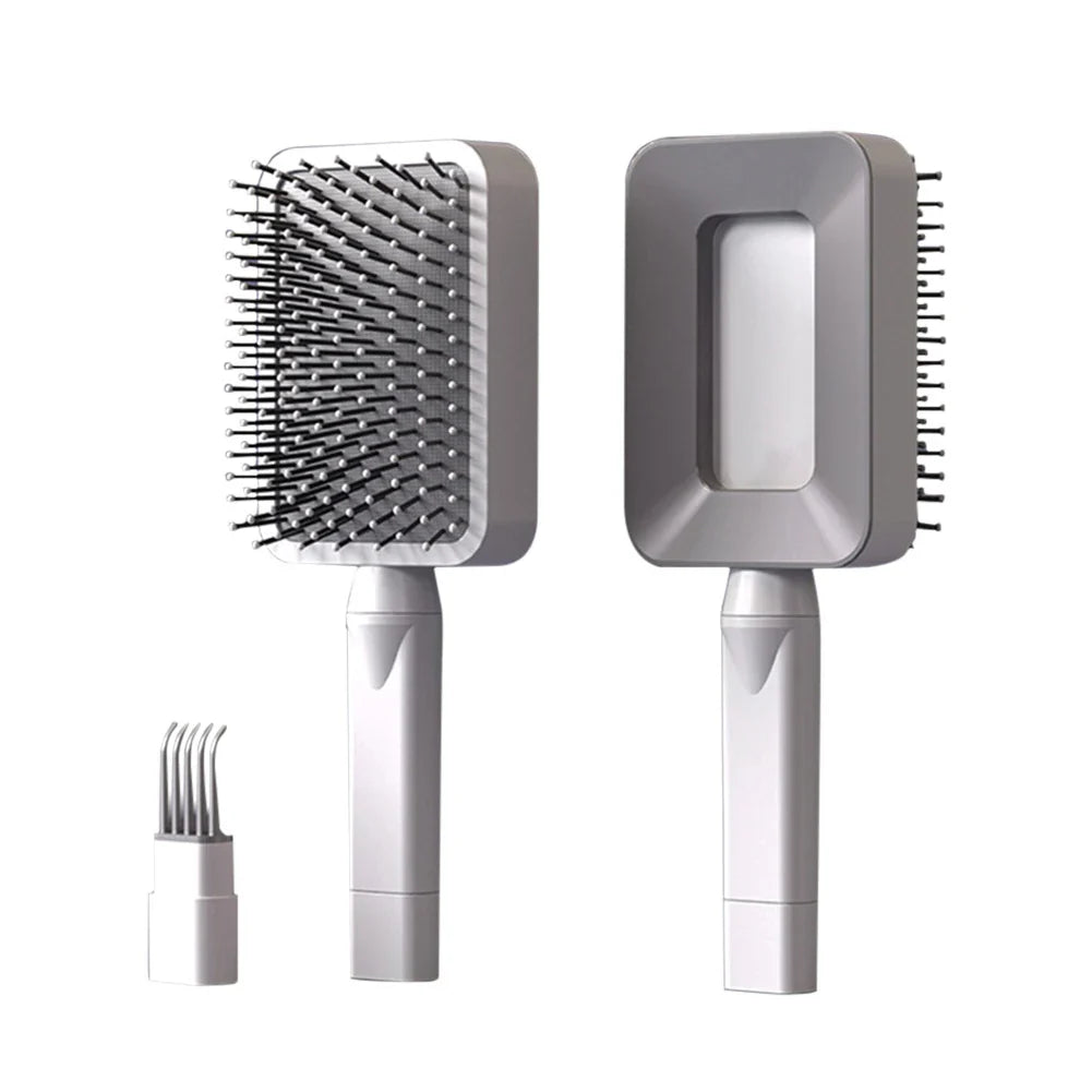 Selbstreinigende Massage-Haarbürsten in Hellgrau mit weißen Akzenten und grauen Borsten – manuelle Entwirrungsbürsten mit ergonomischem Griff und integriertem Reinigungskamm zur einfachen Entfernung von Haaren aus der Bürste.